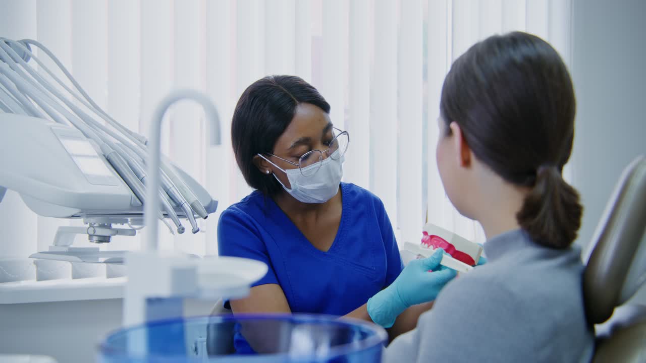 Dentist Examining Patient with Teeth Model