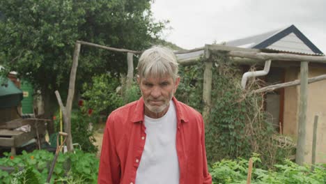 portrait of smiling senior caucasian man working in garden alone