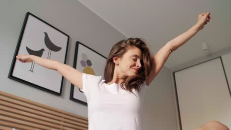 mujer estirándose en la cama después de despertarse