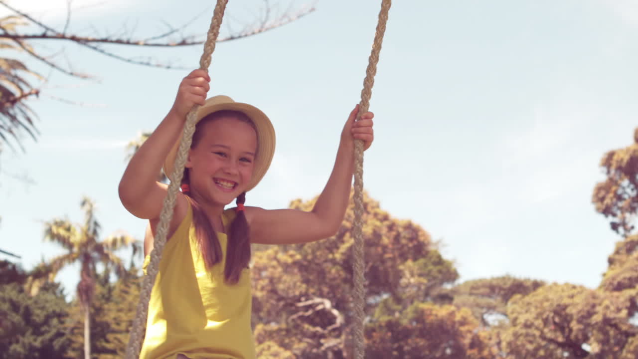 una niña feliz en un columpio en el parque