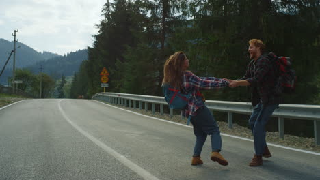 lovers dancing around forest nature on mountains road. couple hold hands outside