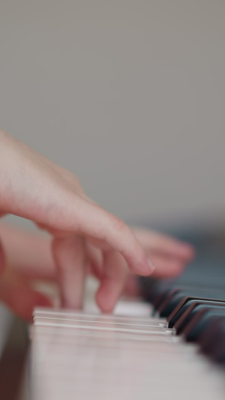 Child hands play piano skillfully. Schoolgirl performs musical composition with smooth hand movements. Expressive playing on musical instrument closeup on blurred background