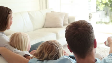 Family-sitting-together-while-watching-television