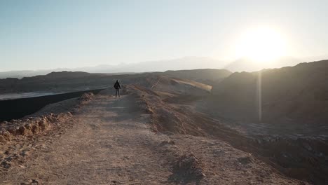 Slow-motion-hiker-walking-on-a-mountain-at-sunrise-in-the-desert