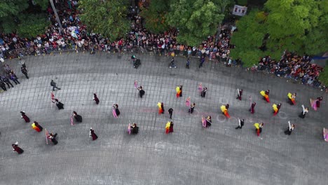 aerial shot of a group of people waving flags during their participation in the day of the dead parade on paseo de la reforma in mexico city