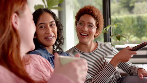 watching tv and relaxing, diverse female friends enjoying time together on couch