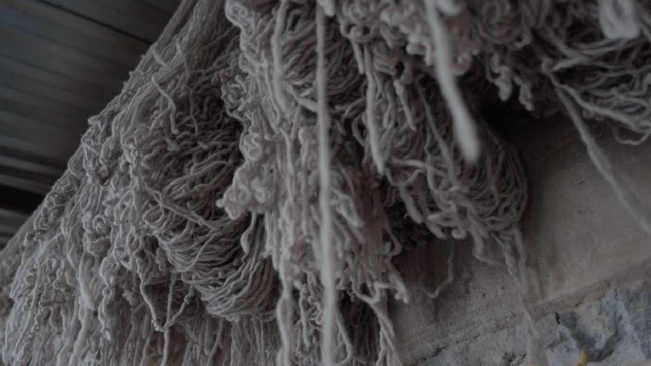 lenta muñeca disparada a lo largo de hilo gris y blanco colgando de ganchos en una casa