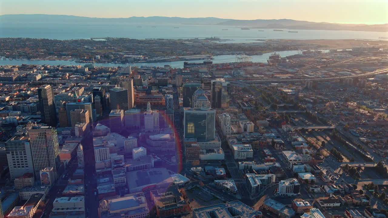 centro de oakland, california distrito de negocios y puerto al atardecer - sobrevuelo aéreo