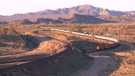 a freight train moves across the desert from a high angle