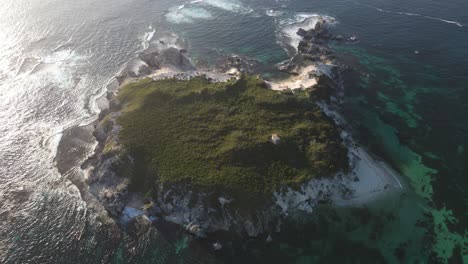 toma aérea de arriba hacia abajo de la isla verde australiana con olas rompiendo durante la luz del sol