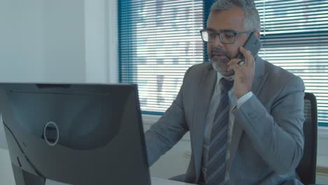 ejecutivo de cabello gris enfocado usando la computadora