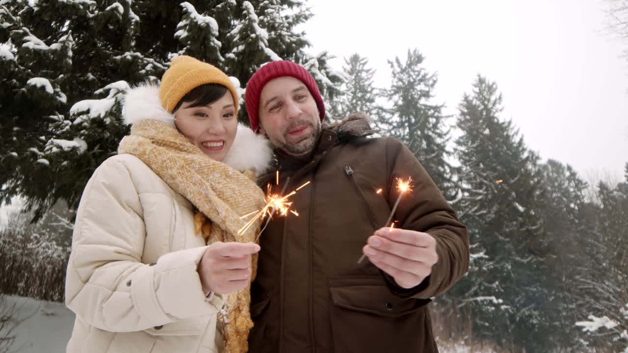 Casal Celebrando em Parque Nevado com Vela de Faísca
