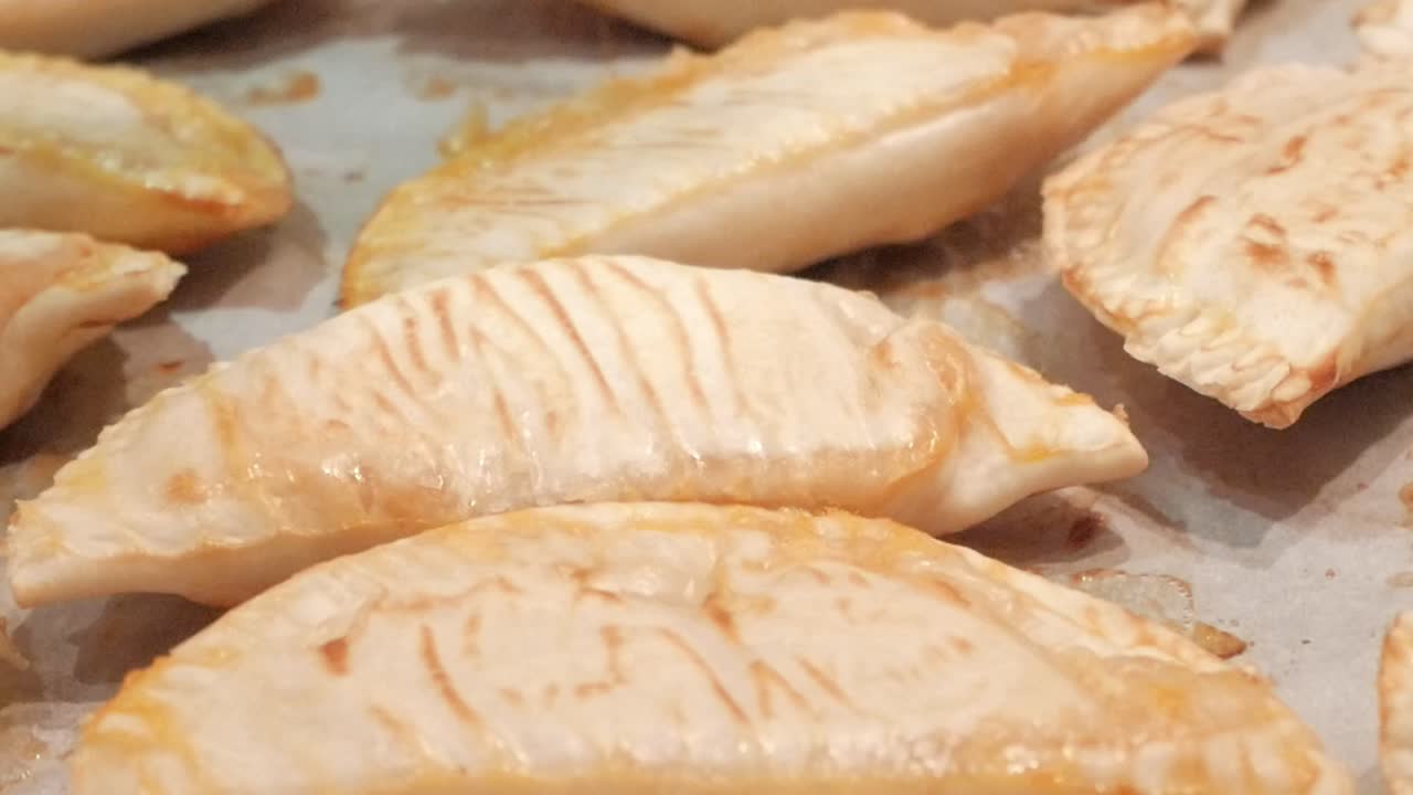 Golden-brown empanadillas fresh from the oven, evoking comfort and homemade warmth