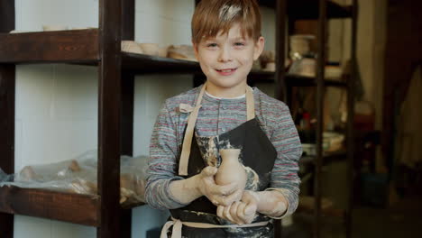 child artist with pottery piece
