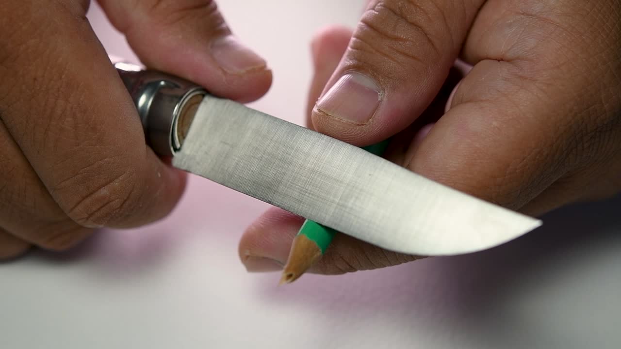 imágenes de manos afilando lentamente un lápiz y algunos lápices de colores con un cuchillo afilado