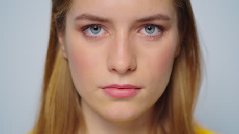 Closeup-beautiful-woman-raising-head-at-camera-on-grey-background.