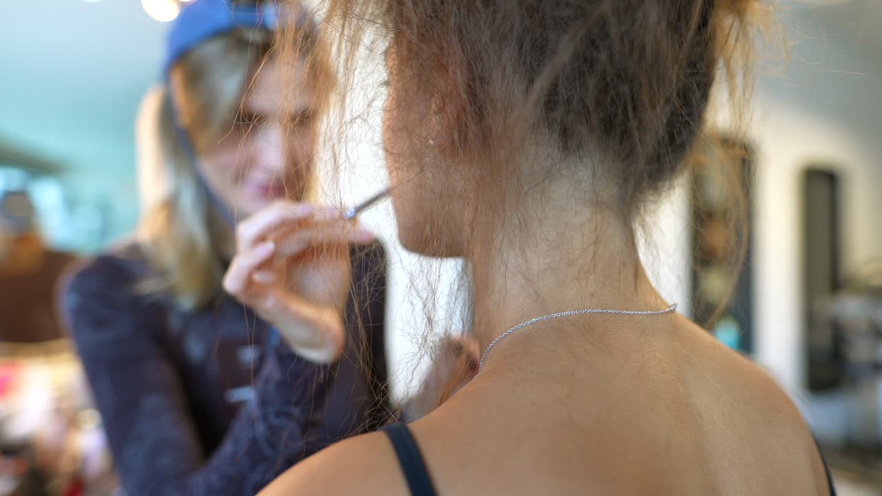 Makeup Artist Applying Cosmetics to a Woman's Face