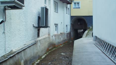 Hallstatt-water-flowing-on-artificial-canal-between-buildings,-static,-day