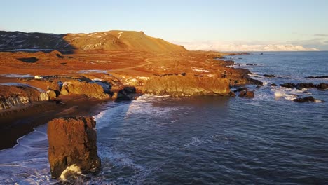 Toma-Aérea-Con-Plataforma-Rodante-A-Lo-Largo-De-La-Costa-Islandesa-Con-Cálida-Luz-Solar-Sobre-El-Hermoso-Paisaje-Escénico