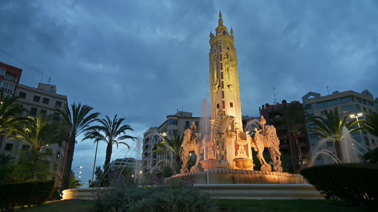 Alicante, Spain - May 19, 2025: Time lapse of people moving through the Plaza de los Luceros Fountain at blue hour