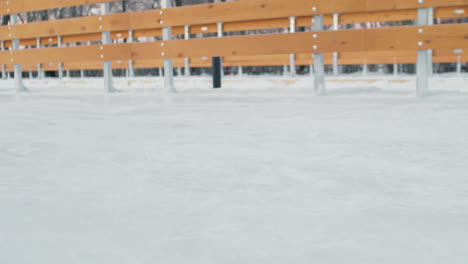 people ice skating on an outdoor rink in winter