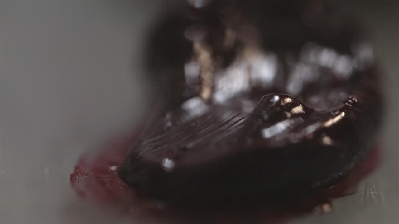 검은 기름 페인트를 퍼뜨리고 밀어내는 페인트 브러쉬의 매크로 클로즈업