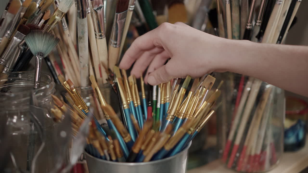 Artista che seleziona i pennelli
