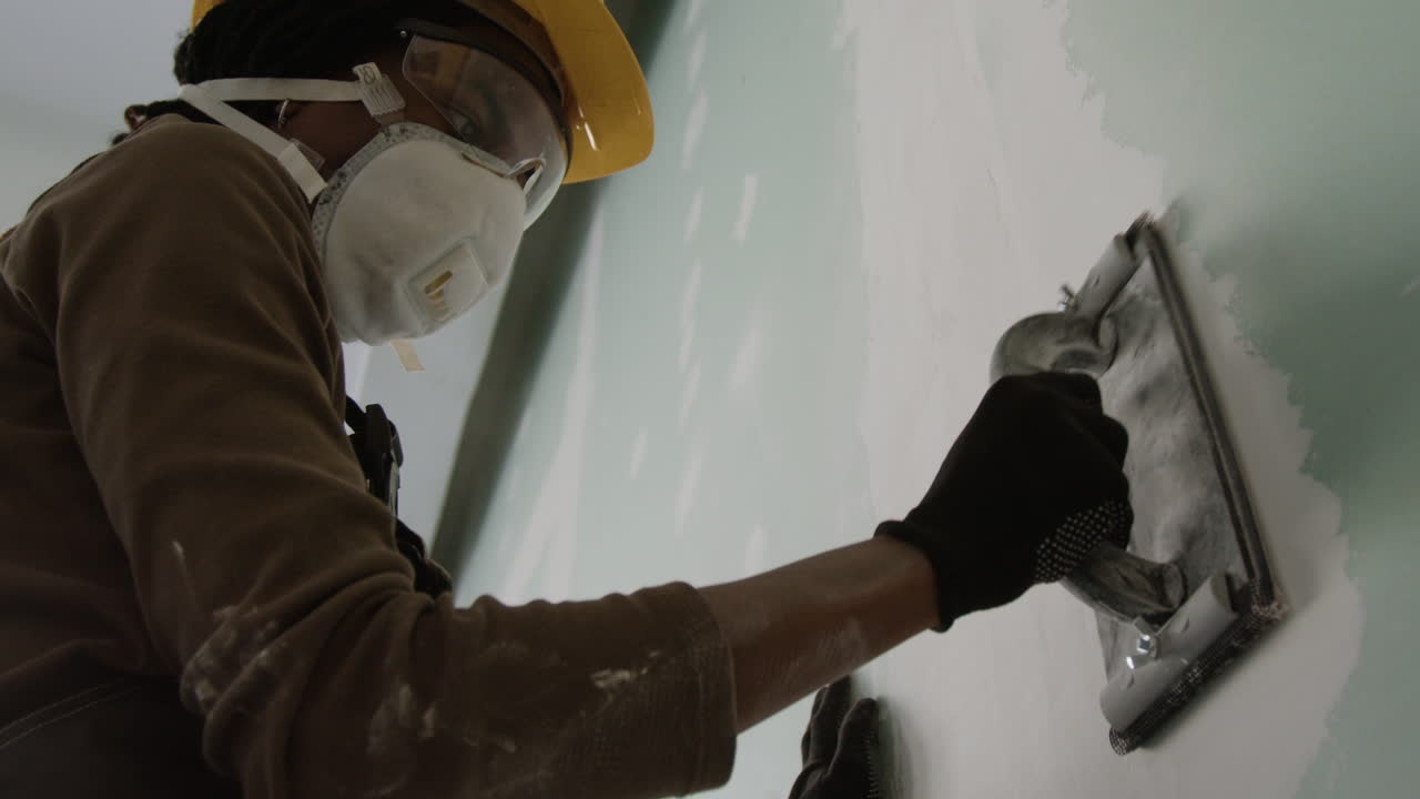 Construction worker smoothing wall surface