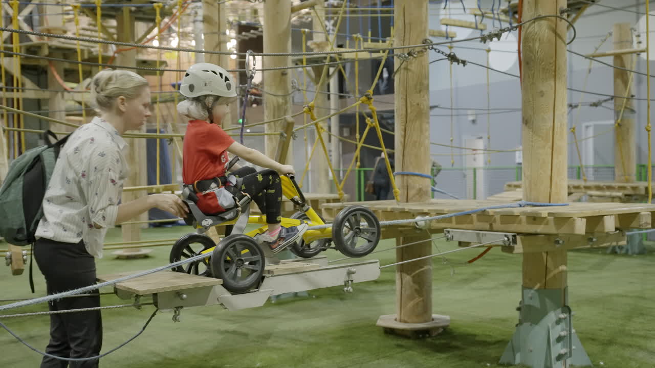 Child and Adult Navigating an Indoor Adventure Rope Course