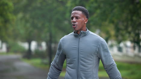 man stretching outdoors in the rain