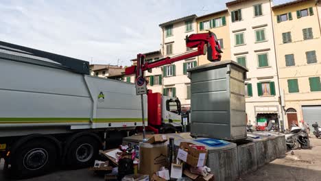 garbage truck empties bins in city street