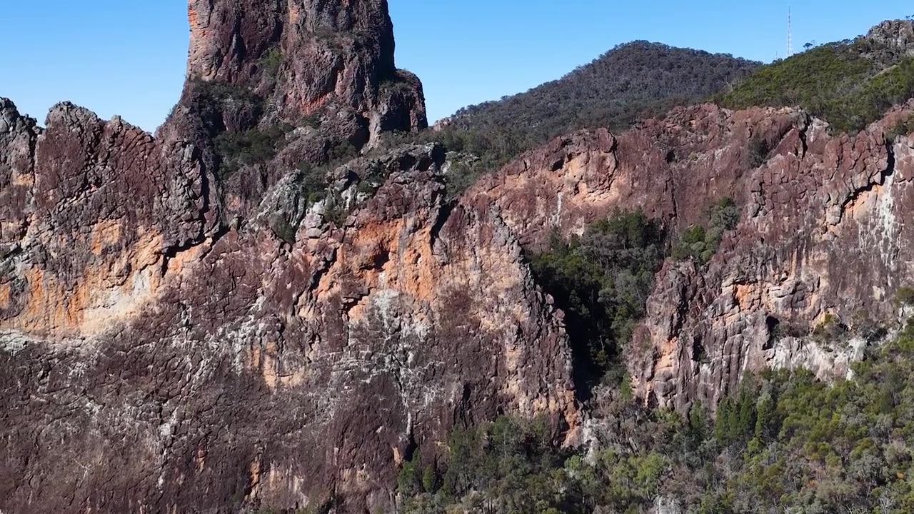 Ripresa panoramica di scogliere vulcaniche frastagliate e vette montuose nel Parco Nazionale di Warrumbungle, Australia