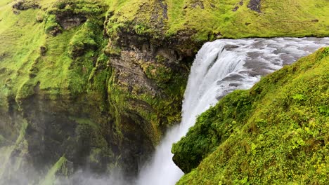 powerful skogafoss waterfall falling in gorge, iceland, high angle view