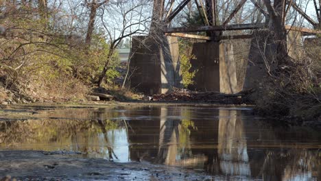 slow pan up from a stream to show the supports of the pope lick railroad trestle in louisville kentucky