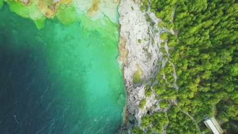 Aerial-shot-of-the-cliffs-by-the-turquoise-water