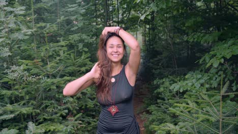 Smiling-Pretty-Lady-In-Black-Dress-At-Wilderness-With-Lush-Green-Foliage-At-The-Background