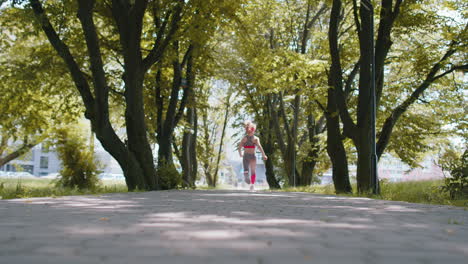 rear view of athletic fit sport jogger teen girl training marathon run, running forward on road