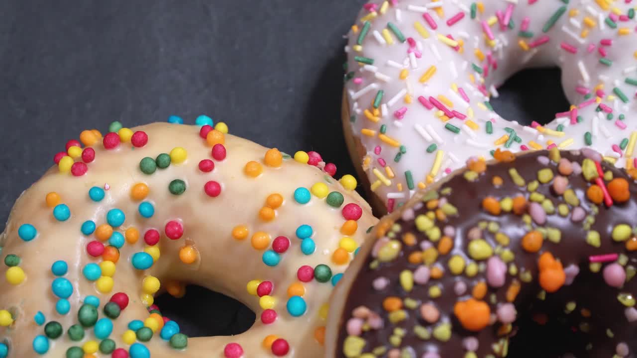 сладкие пончики, вращающиеся на темном фоне. традиционная американская сладость