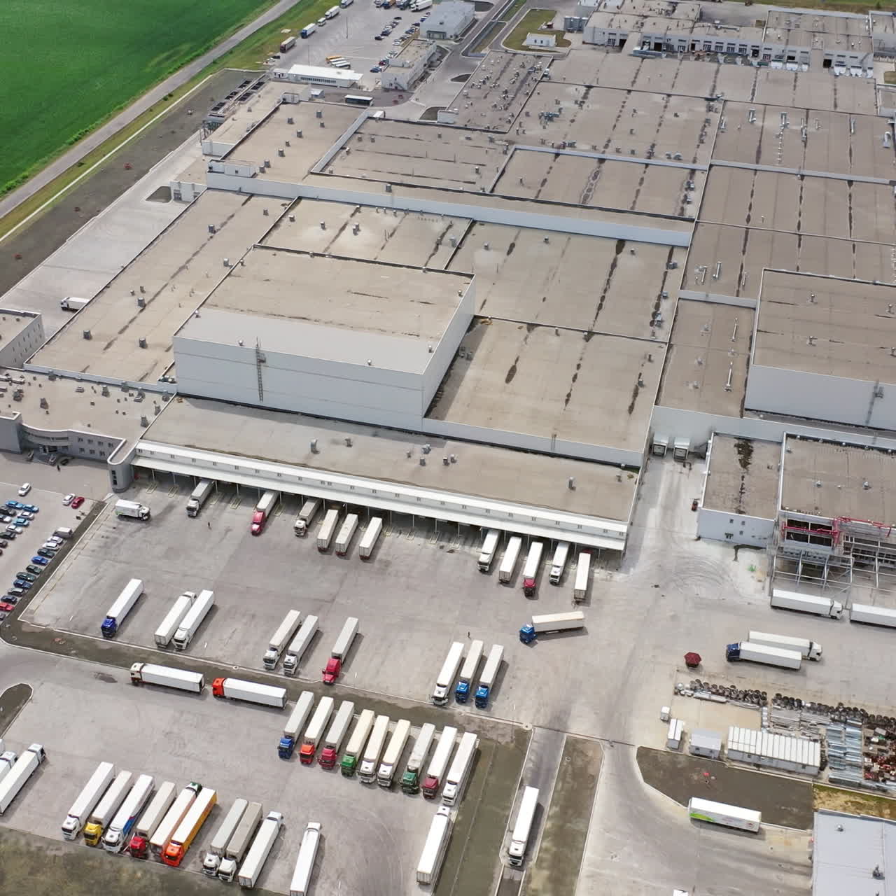 Moderne industriområde med store lastbiler udendørs. Luftfoto af et enormt produktionskompleks om sommeren. Kameraet bevæger sig op. Slowmotion