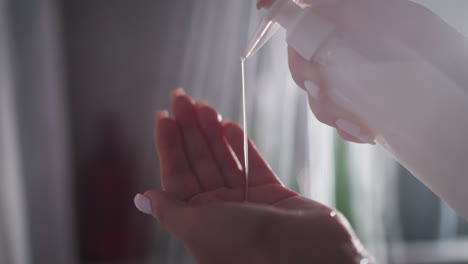 woman pours liquid soap on palm in bathroom closeup. lady takes cream gel from dispenser bottle in shower cabin. body wash cosmetic product