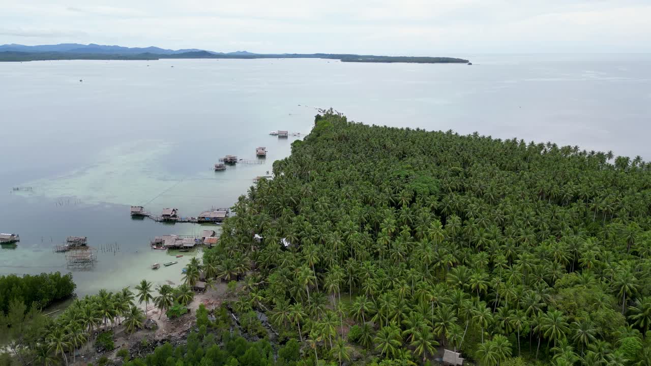 발라박 섬 의  ⁇ 나무 정글 의 가장자리 를 따라 기둥 위 에 있는  ⁇ 시 마을 의 오두막 집 들