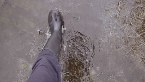 hombre en botas de agua caminando por charcos húmedos de marismas, punto de vista de cámara lenta