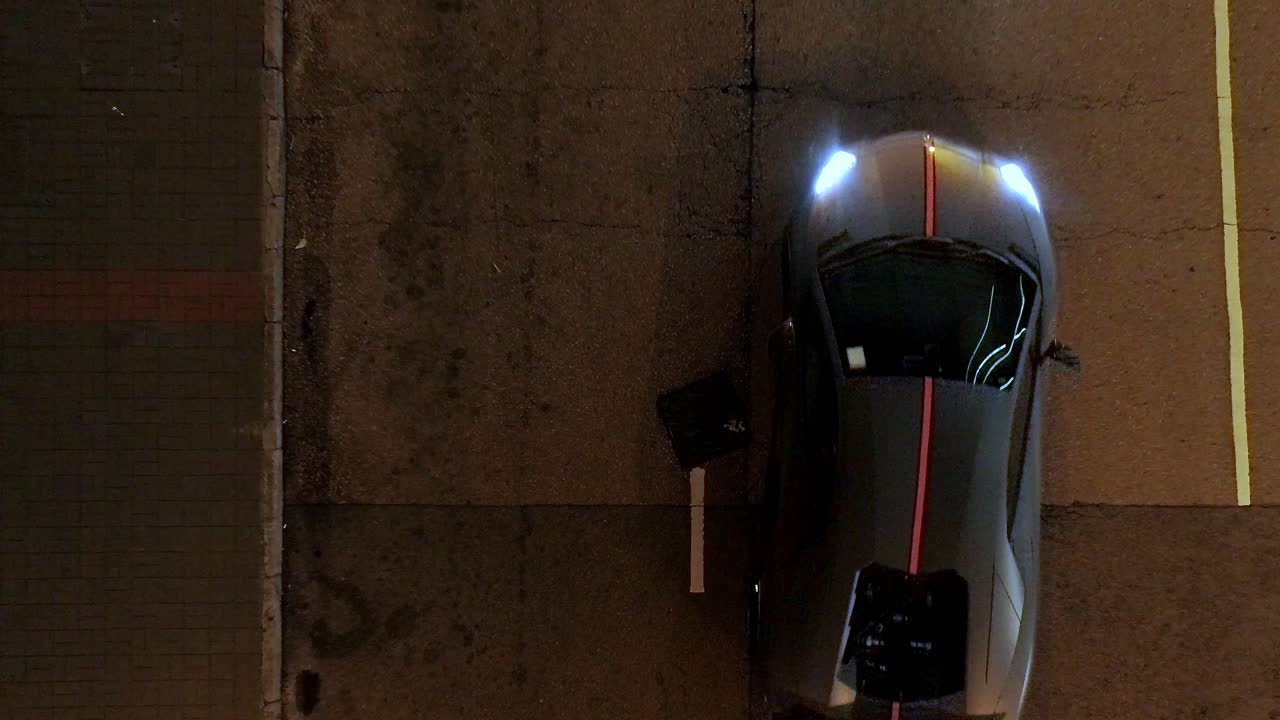 밤에 도시 거리에서 어두운 회색 스포츠 자동차