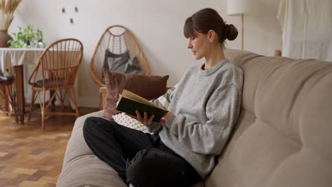mujer leyendo un libro en un sofá