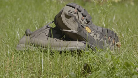 dolly in of worn hiking shoes in a grass field