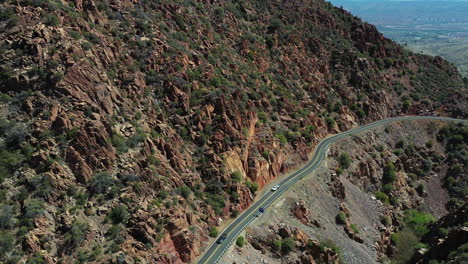 Vista-Aérea-Del-Tráfico-De-La-Autopista-En-La-Ladera-De-Una-Colina-En-El-Desierto-De-Arizona-Cerca-De-La-Ciudad-De-Jerome