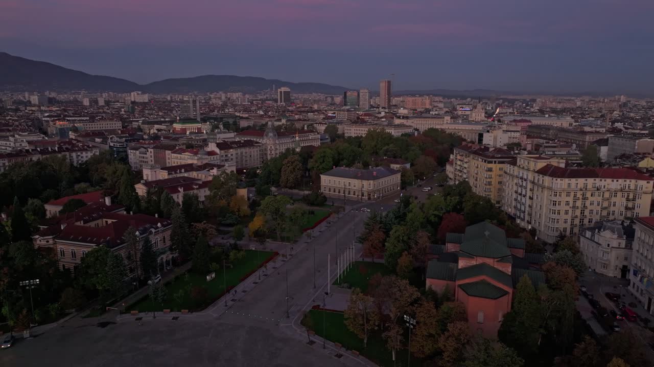 Vista de dron del amanecer proyectando tonos cálidos sobre el perfil urbano de Sofía, Bulgaria