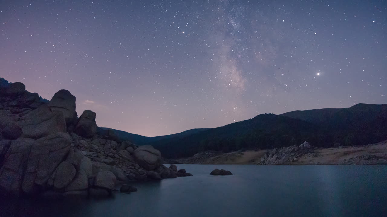timelapse da via láctea sobre um lago