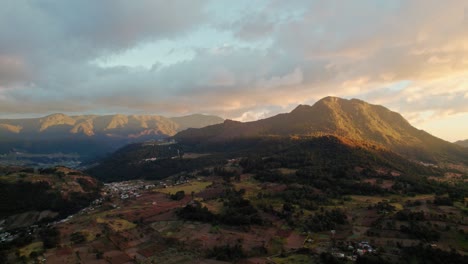 vista aérea de drones de la puesta de sol de la hora dorada sobre el volcán guatemalteco implosionado y el valle del campo
