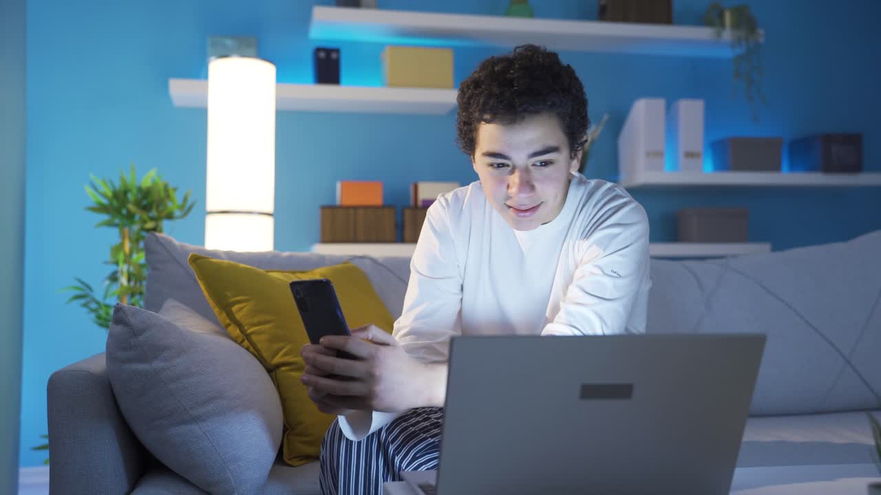 un niño lindo y feliz mirando su teléfono inteligente en casa, enviando mensajes de texto, usando las redes sociales.